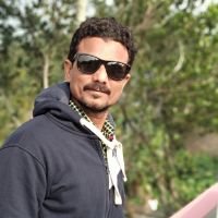 Cliente satisfecho al aire libre con gafas de sol y buzo azul oscuro, posando con confianza y actitud relajada - cliente feliz, experiencia positiva, confianza, testimonio visual, reseña cliente real. | Diseño Web – SZ Web Design.