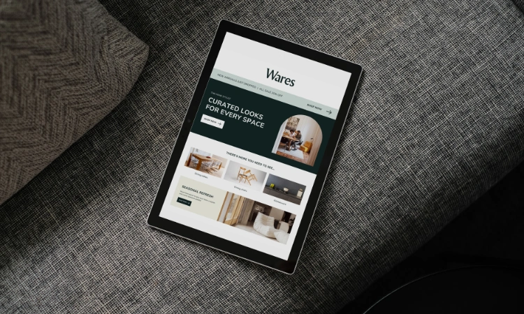 Página de una tienda de decoración vista desde una tablet en un sofá gris.