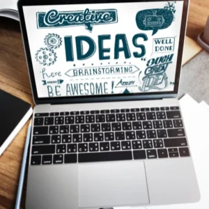 Laptop con pantalla mostrando diseño creativo con ideas y conceptos de brainstorming.