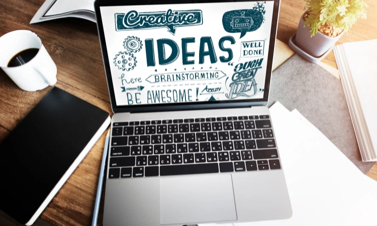 Laptop con pantalla mostrando diseño creativo con ideas y conceptos de brainstorming.