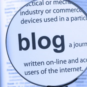 Lupa resaltando la palabra blog en un texto impreso.