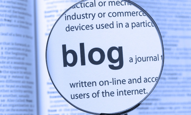 Lupa resaltando la palabra blog en un texto impreso.