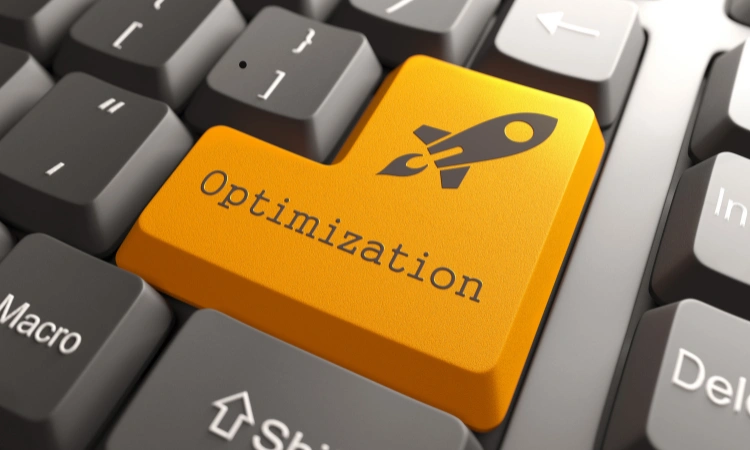 Teclado de computadora con tecla amarilla de optimización y símbolo de cohete, representando mejora y optimización de procesos digitales.