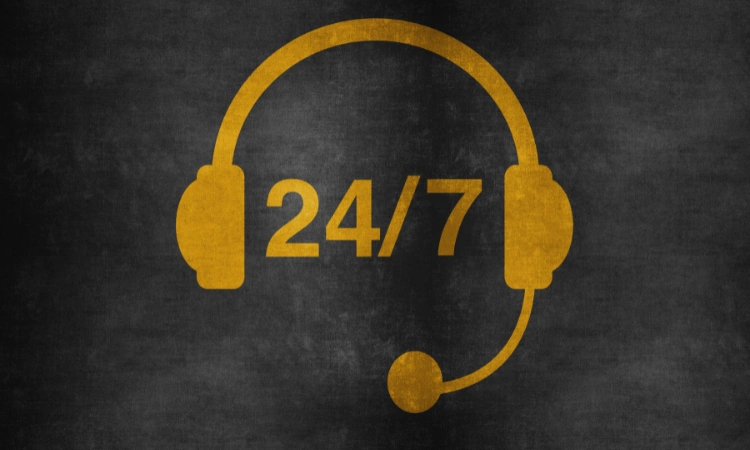 Icono de auriculares con micrófono y reloj 24/7 en color dorado sobre fondo oscuro, representando atención al cliente 24 horas.