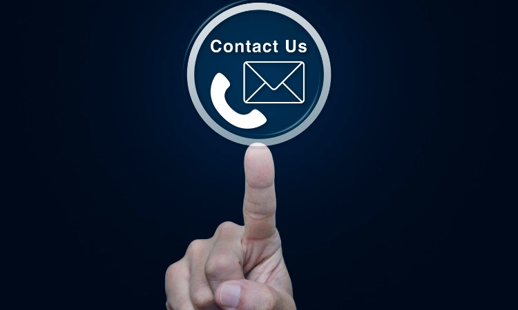 Mano tocando icono de contacto con símbolo de teléfono y correo en pantalla digital.