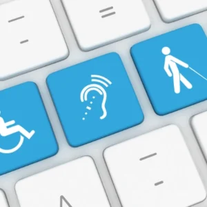 Teclado con teclas azules que representan accesibilidad para personas con discapacidad física, auditiva y visual.