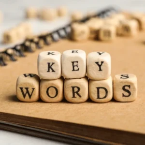 Bloques de madera con letras formando la palabra "keywords" sobre un cuaderno, representando estrategias de palabras clave para SEO.